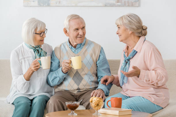 istock senior people drinking coffee and talking in nursing home 1064954966