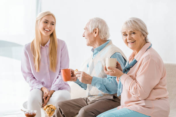 istock young woman talking and drinking tea with senior parents on sofa 1064955046
