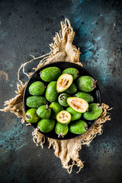 Raw organic feijoa Tropical fruit, raw organic feijoa on a dark blue concrete background, copy space pineapple guava stock pictures, royalty-free photos & images