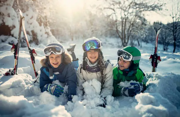 Photo of Happy kids skiing in beautiful winter forest