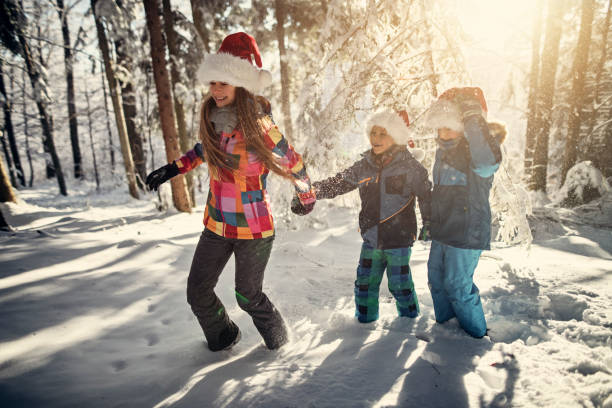 istock Kids enjoying winter forest on Christmas 1064957912