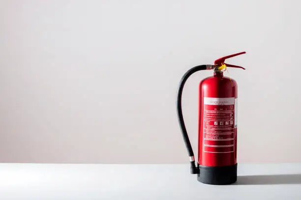 Close view of a red fire extinguisher on a table.