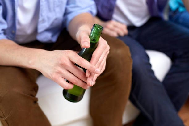 istock men with beer bottles sitting on sofa at home 1064962322