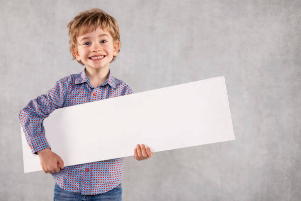 istock young businessman holding an advertising space in his hands, white copy space 1064965074