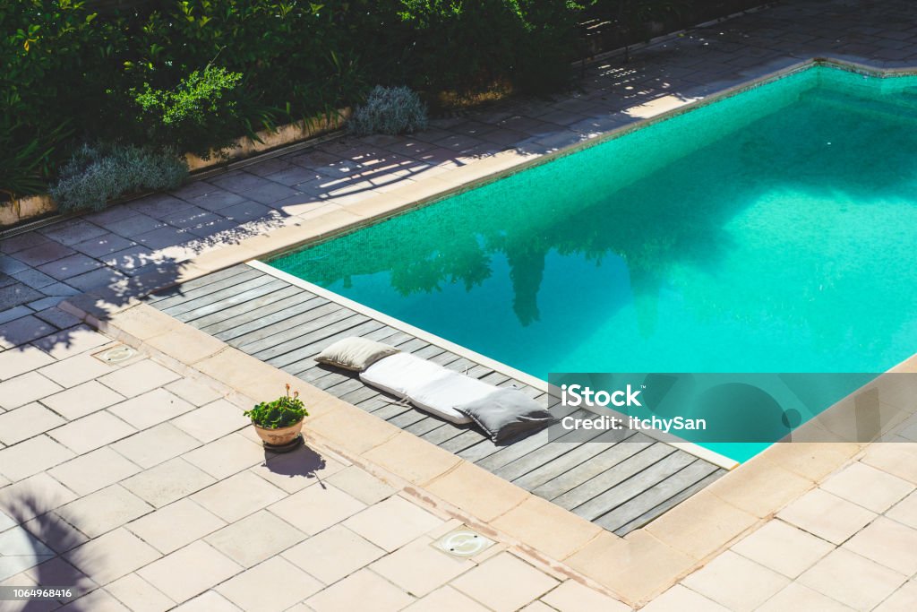 Swimming pool Swimming pool with clean turquoise water in it. Narrow wooden deck for sunbathing next to the pool. Swimming Pool Stock Photo