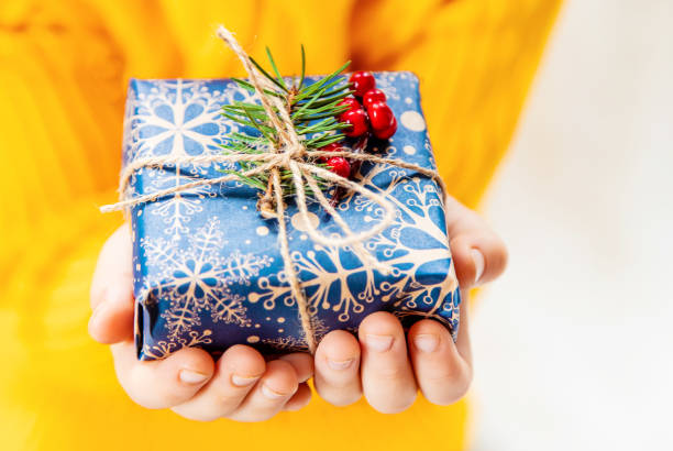 istock Child holds a Christmas decor and gifts on a white background. Selective focus. 1064969970