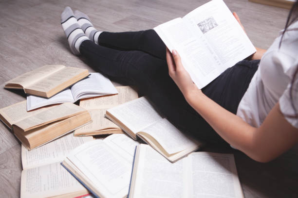 istock girl reading sitting on the floor 1064970486