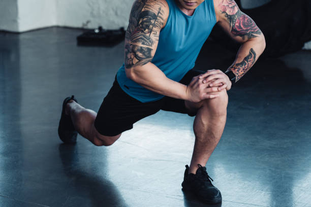 istock focused young sportsman doing lunge exercise at gym 1064972846