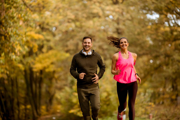 istock Young couple jogging together in park 1064973540