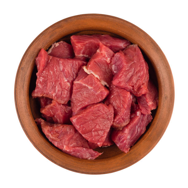 istock Raw meat is cut into pieces in a brown plate. Isolated on white background. Top view. 1064980996
