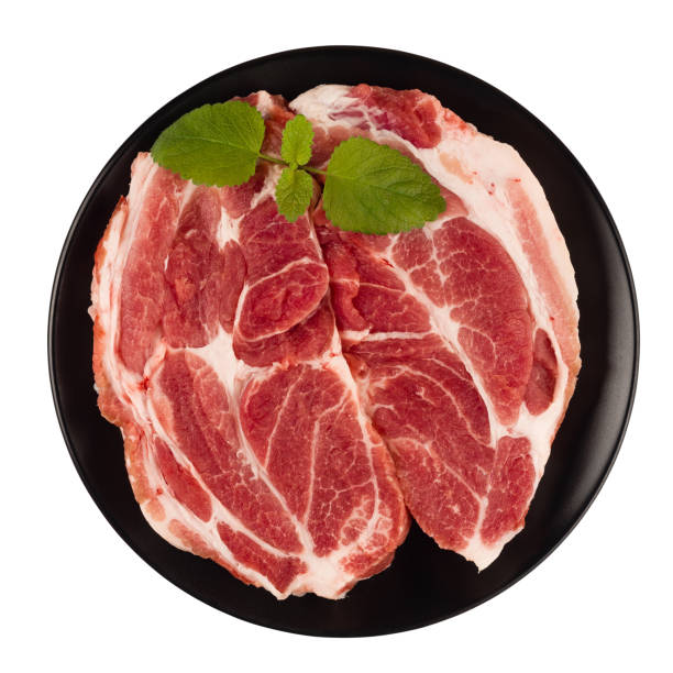 Raw pork neck meat cuts on a plate top view isolated on white background fresh two\