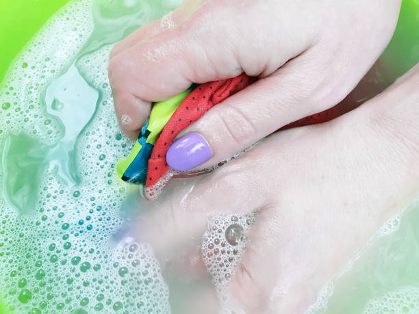 istock female hands washing clothes closeup 1064985936