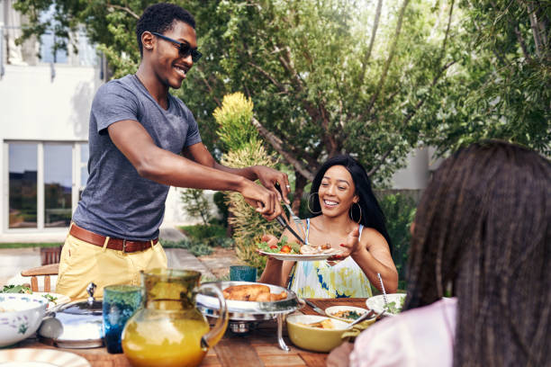 I'm a happy man when I have my family around Shot of a happy family having lunch out in the backyard south african braai stock pictures, royalty-free photos & images
