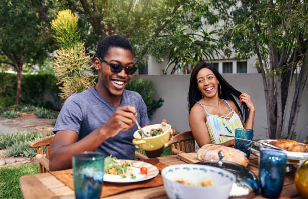 Weekends are all about family catch ups Shot of a happy family having lunch out in the backyard back yard stock pictures, royalty-free photos & images