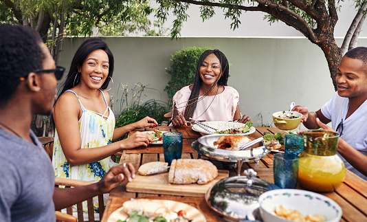 Shot of a happy family having lunch out in the backyard