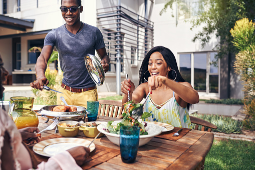 Shot of a happy family having lunch out in the backyard