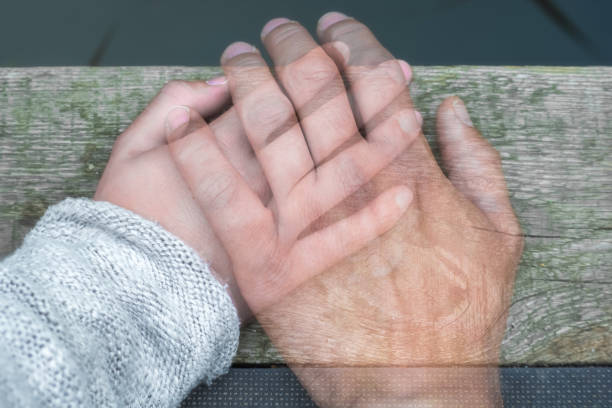 main de l’homme semi transparent sur la main d’une femme comme un signe d’adieu de séparation ou de décès - mort description physique photos et images de collection