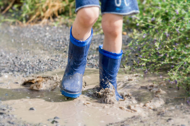 istock Child jumps carefree in a puddle 1064987874