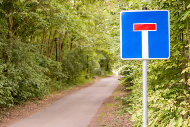 strada forestale con cartello come segno per un vicolo cieco - segnale di strada senza uscita foto e immagini stock