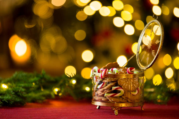 Close-up gingerbread and candy cane jar. Happy family holiday. Living room decorated with lights and candles and Christmas tree. Holiday mood
