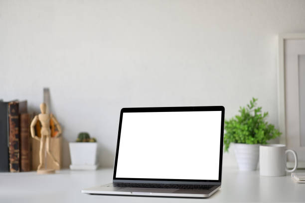 istock Workspace with blank white screen laptop on loft desk. 1064988114