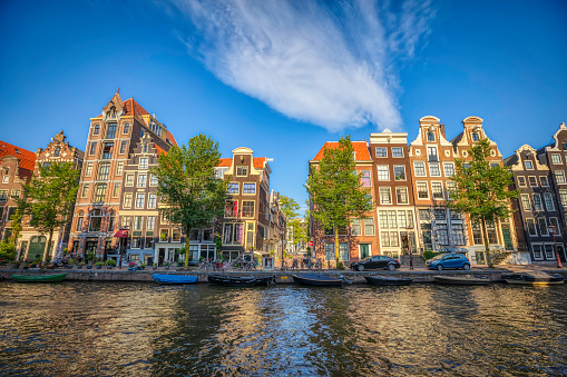 Amsterdam city scene with typical water canal and bridge in sunny day