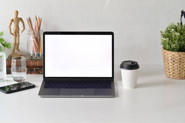 istock Designer workspace with blank white screen laptop and office accessories 1064988534