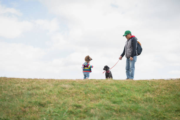 istock Father and son with dog on small hill 1064989262