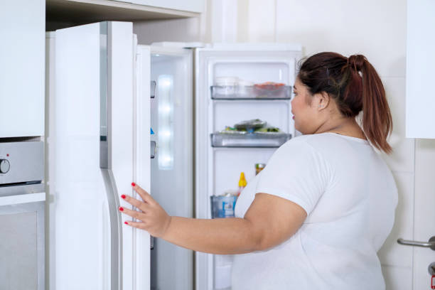 istock Young woman checking foods in refrigerator 1064990454