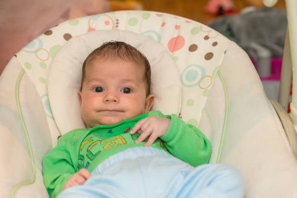 istock The newborn lies on swing automatic electrical chair and enjoys it 1064991296