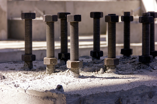 View of the anchor bolts for fondation in the concrete. An anchor bolt is a fastener used to attach objects or structures to concrete. There are many types of anchor bolts.