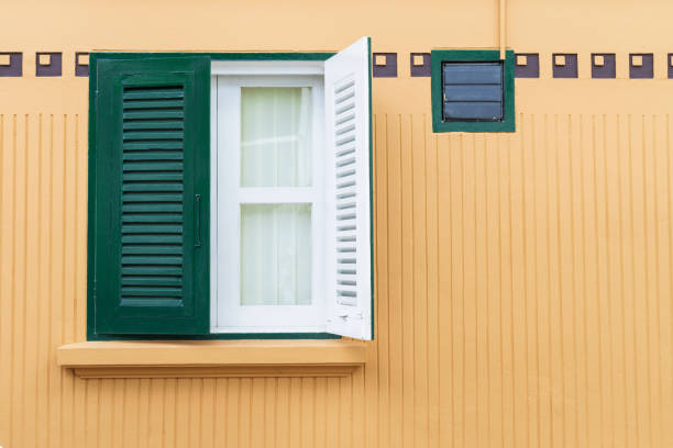 istock Green window on the yellow wall. 1064997008