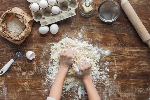 istock top view of female hands making dough on wooden table 1065008146