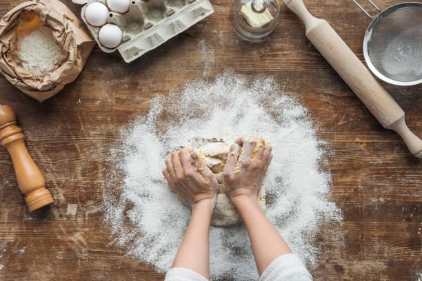 istock top view of female hands making dough on wooden table 1065008156