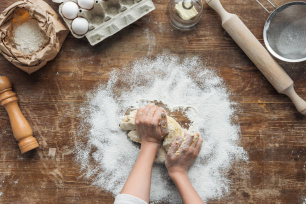 istock top view of female hands making dough on wooden table 1065008220