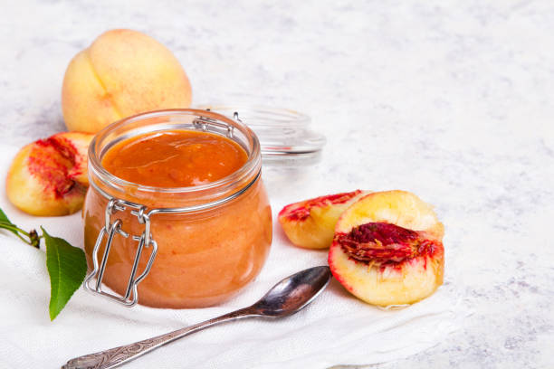 homemade peach jam with organic fruit. sweet preserves on a light background, copy space - preserves jar apricot marmalade imagens e fotografias de stock