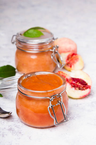 homemade peach jam with organic fruit. sweet preserves on a light background, copy space - preserves jar apricot marmalade imagens e fotografias de stock