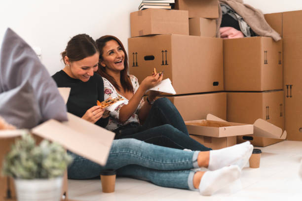Best friends eating pizza while moving home