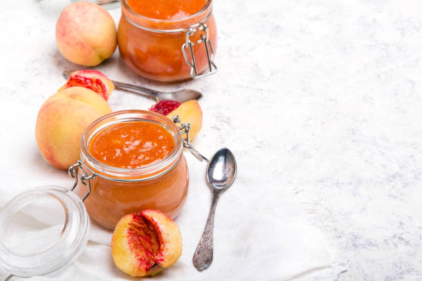 homemade peach jam with organic fruit. sweet preserves on a light background, copy space - preserves jar apricot marmalade imagens e fotografias de stock