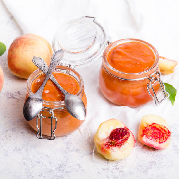 homemade peach jam with organic fruit. sweet preserves on a light background, copy space - preserves jar apricot marmalade imagens e fotografias de stock