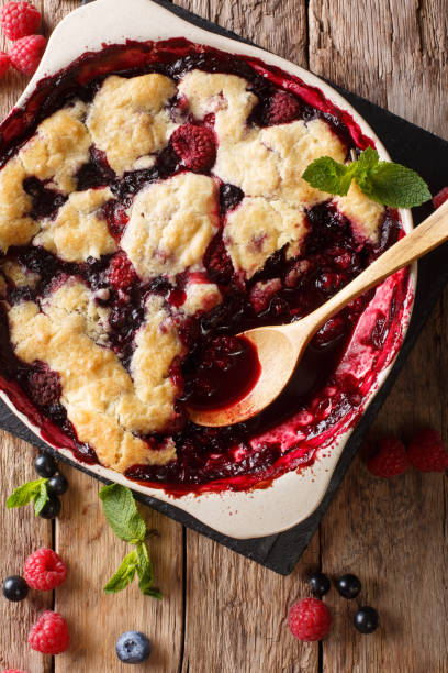 istock Berry cobbler with currants, raspberries and blueberries decorated with mint close up.  vertical top view 1065013148