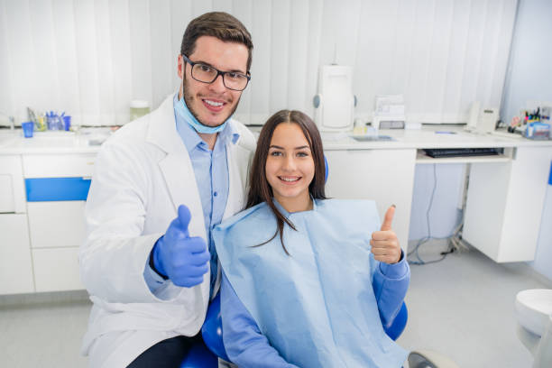 Dentist doctor and little girl smiling at camera. Thumb up stock photo