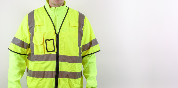 A man with warning safety clothes for roadworks and construction sites. High visibility reflective yellow safety vest. Plenty of copy space for your own text.