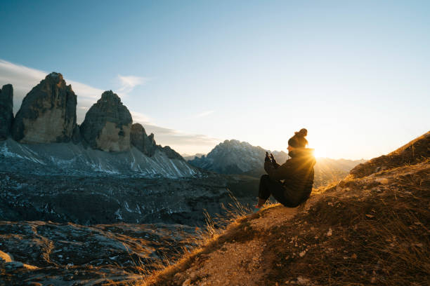 Female hiker looks at view at sunset Mountains behind, Dolomites finding photos stock pictures, royalty-free photos & images