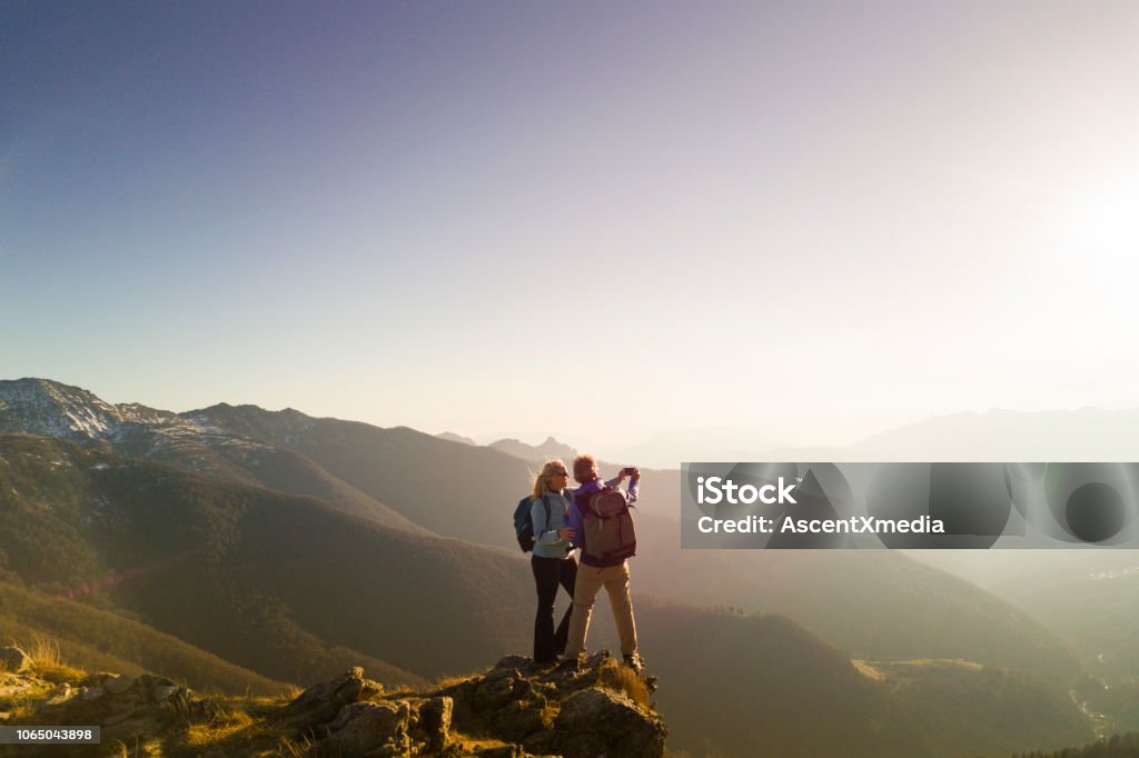 Hiking couple take selfie Mountain range behind Couple - Relationship Stock Photo