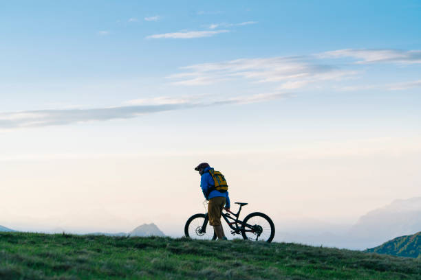 istock Man mountain bikes up grassy slope 1065043906