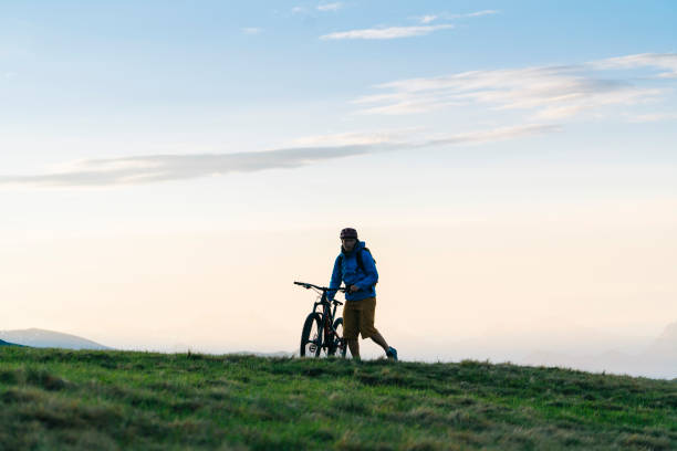 istock Man mountain bikes up grassy slope 1065043918