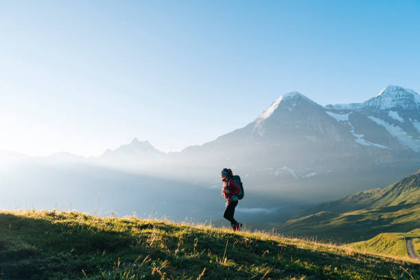 istock One young female hiker walks up hill 1065044056