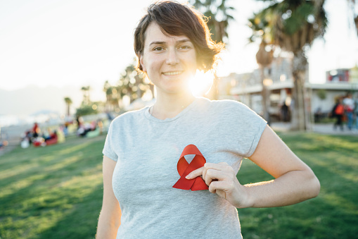 Young woman with red AIDS awareness ribbon