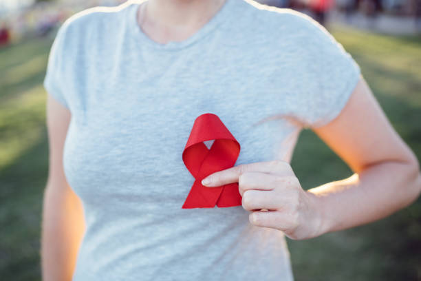 руки, держащие красную ленту осведомленности о спиде - aids awareness ribbon фотографии стоковые фото и изображения